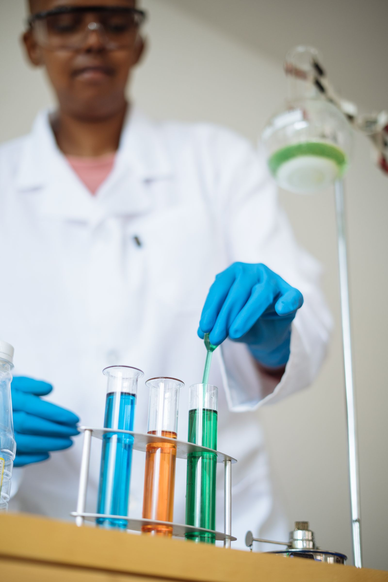 A student in a lab coat carrying out a chemistry practical.